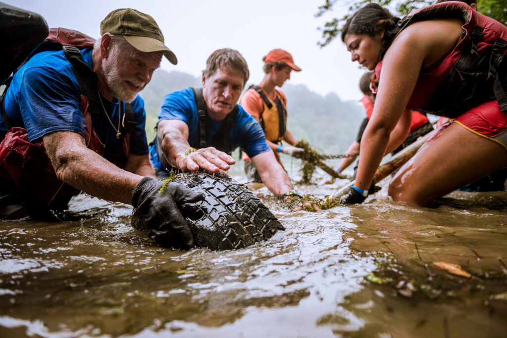 Group of people remove tire from river