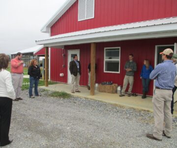 People stand outside of barn