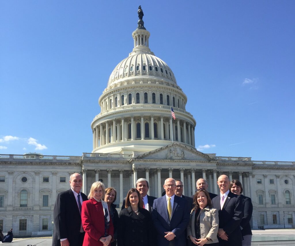 Group of people pose in front of US Capitol building