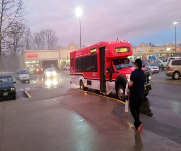 Woman approaches red transit bus